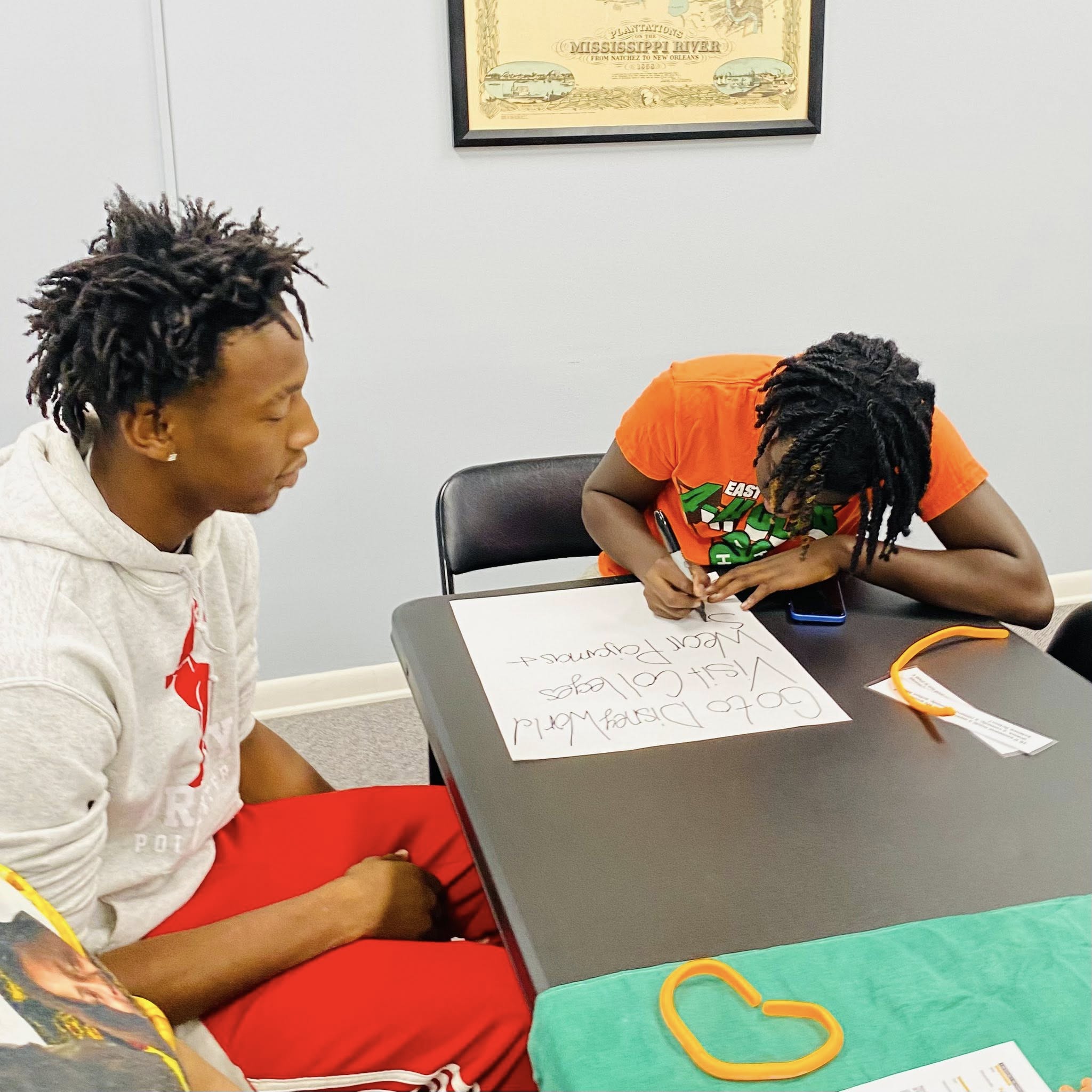 Two teenage boys working on a poster.